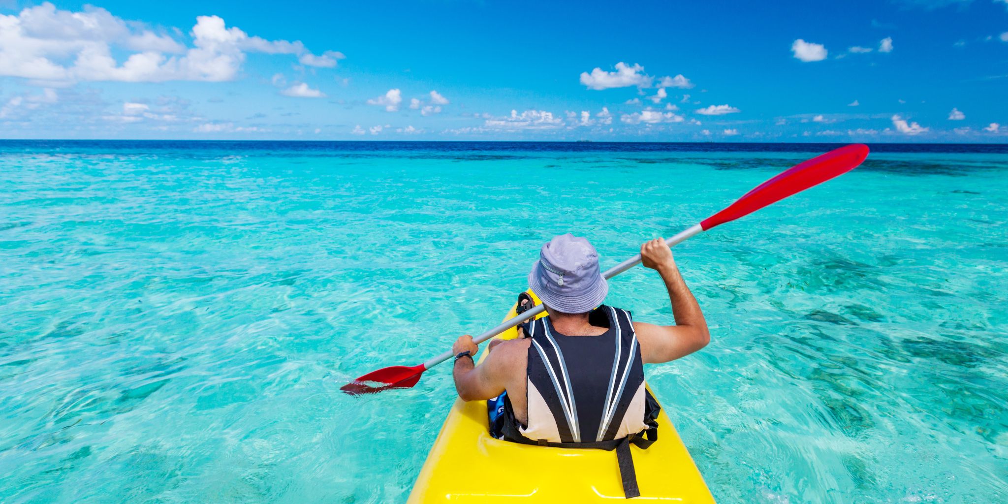 Hombre remando con un kayak en Maldivas